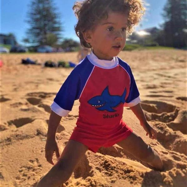 little boy on the beach wearing our ozi varmints boy leg swim shorts nylon