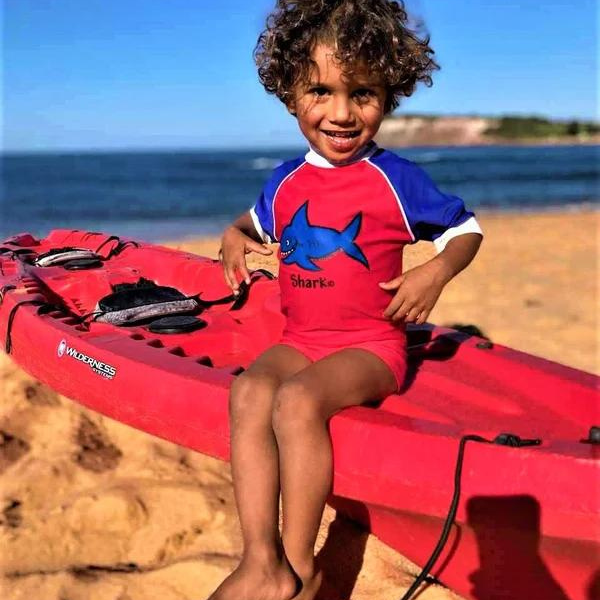little boy on the beach wearing our ozi varmints boy leg swim shorts nylon