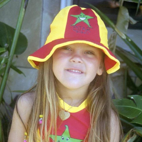 a baby girl wearing the ozi varmints lycra panel hat with a starfish design print - red sun